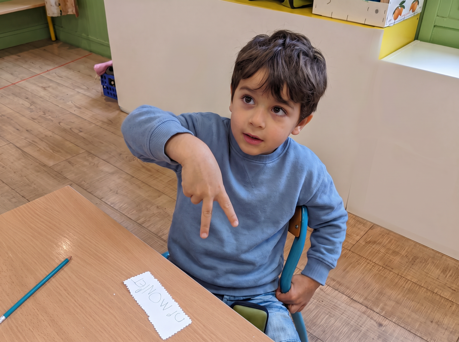 Niña frente a un panel de tarjetas de signos